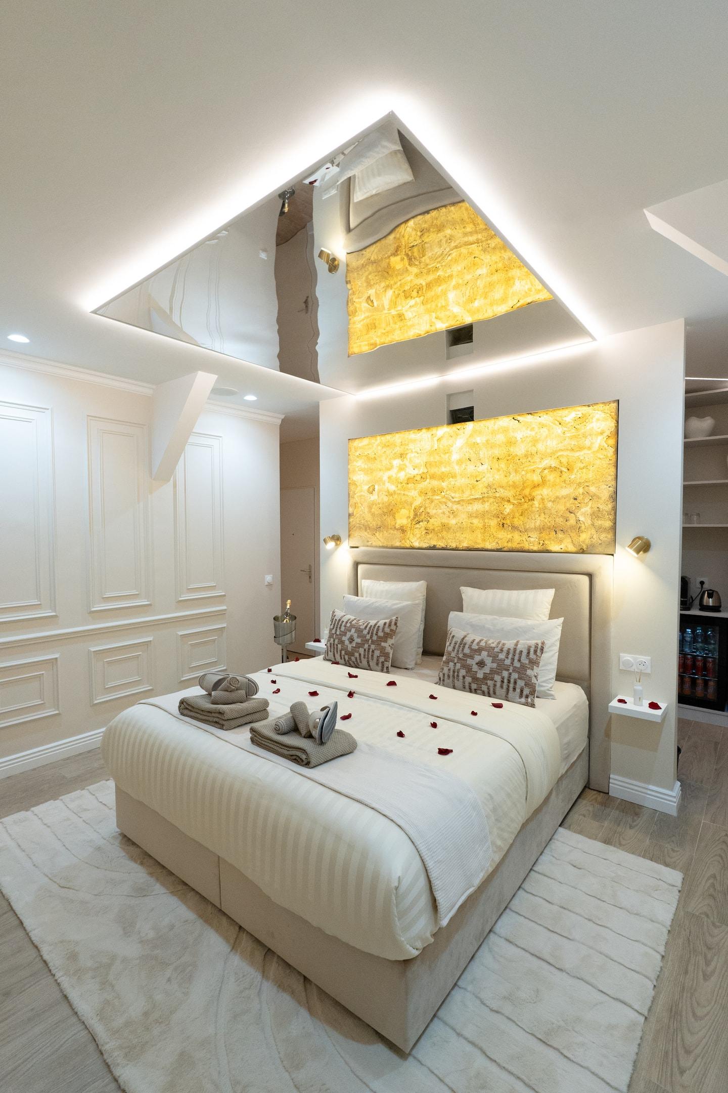 La chambre et sa tête de lit dorée rétroéclairée, moulures blanches