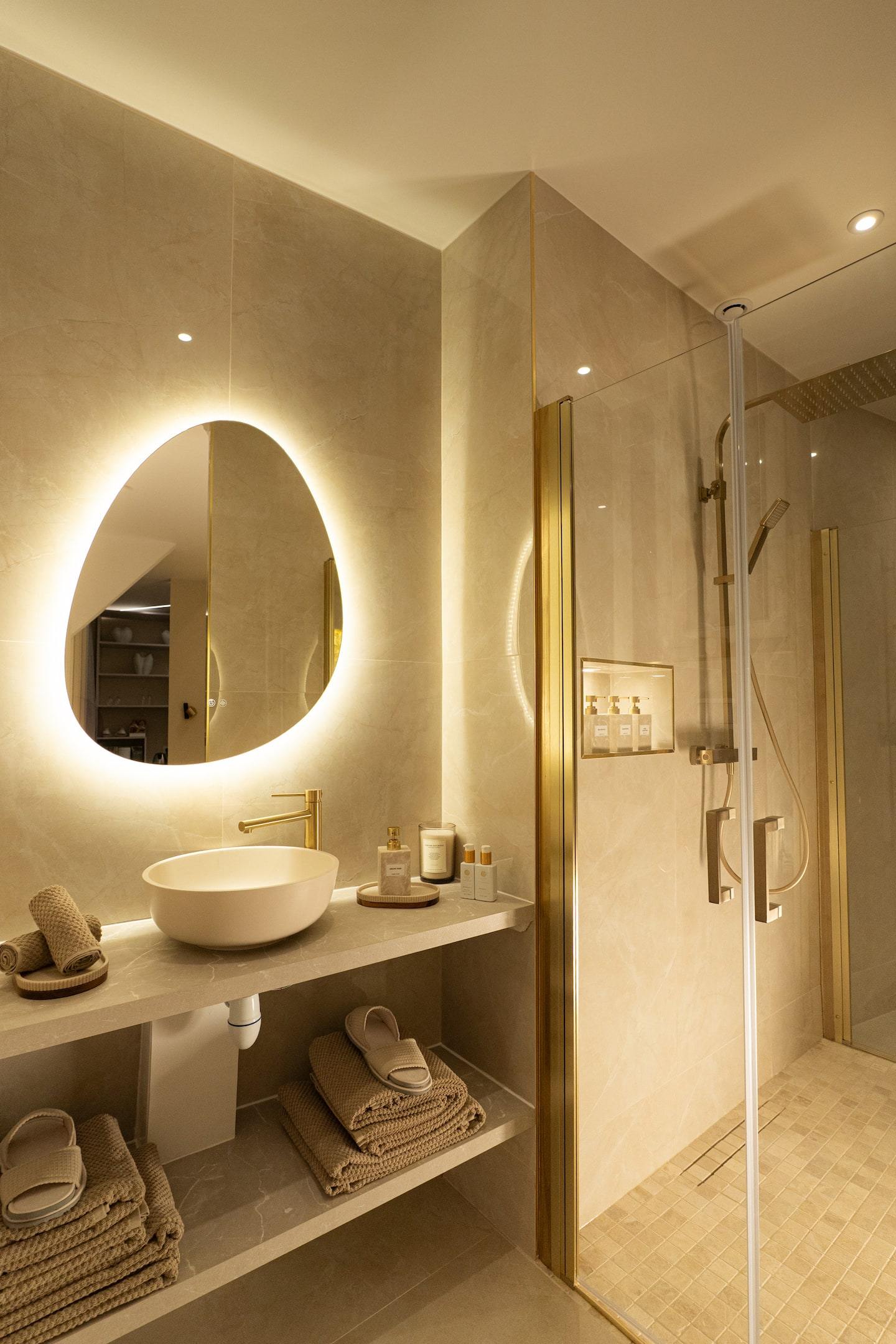 La salle de bain, miroir organique rétroéclairé et douche à l’italienne