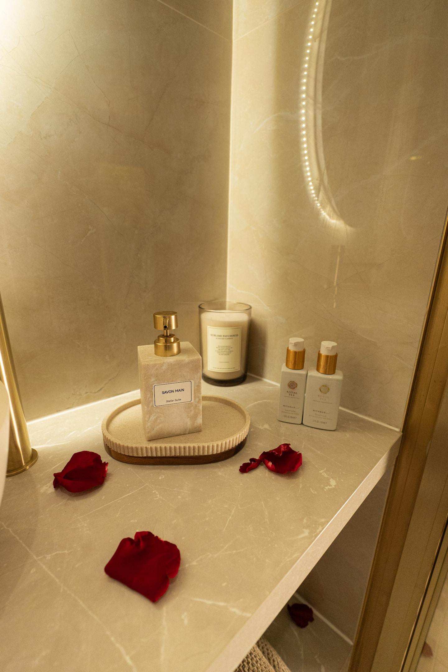 Bougie, parfums et pétales de rose sur le plateau de marbre