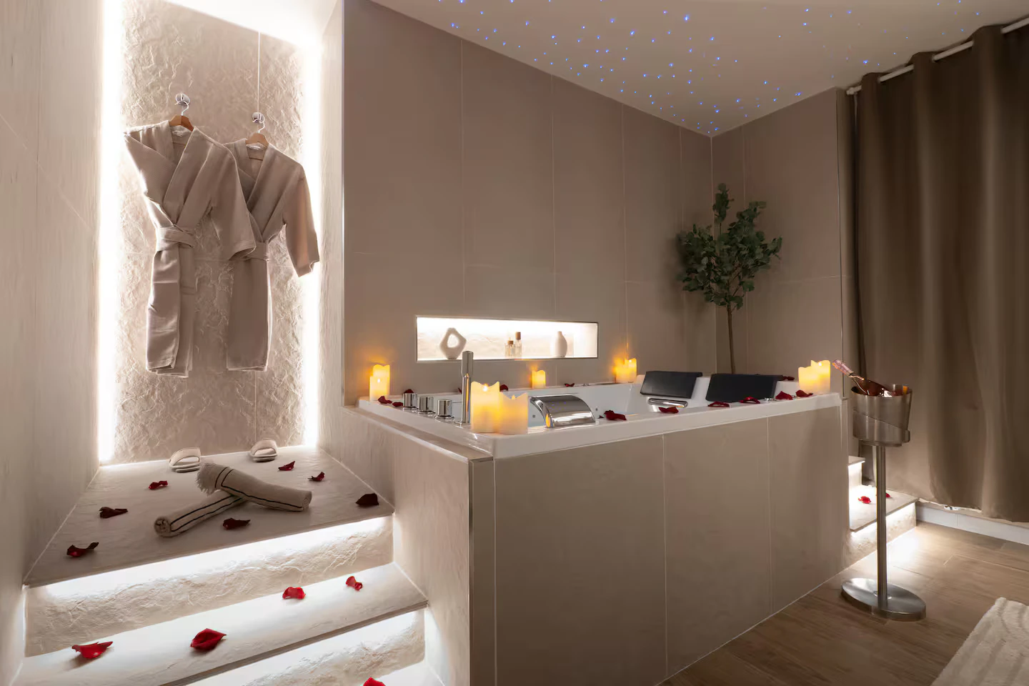 Le jacuzzi de la Stellar Suite, entouré de bougies, de pétales de rose et de peignoirs